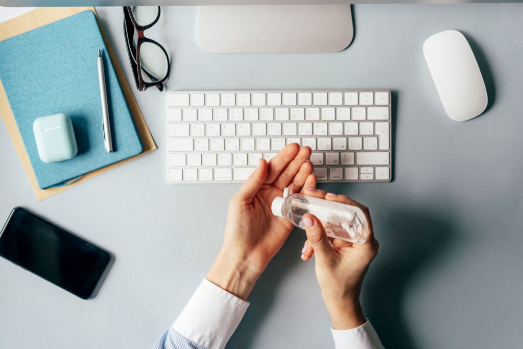 Person using hand sanitiser at desk