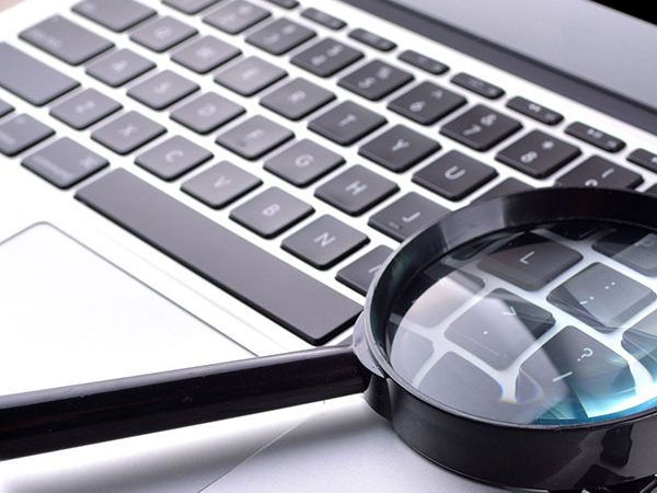 Laptop and magnifying glass
